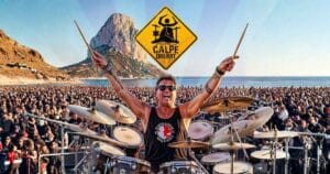 Een drummer met tal van mensen rond zich met de Ifach rots in de achtergrond
